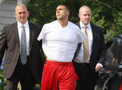Hernandez being escorted out of his house in handcuffs Wednesday. 